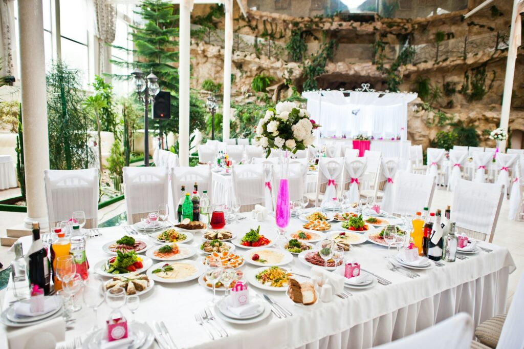 Wedding guest table with flowers and food at wedding hall.