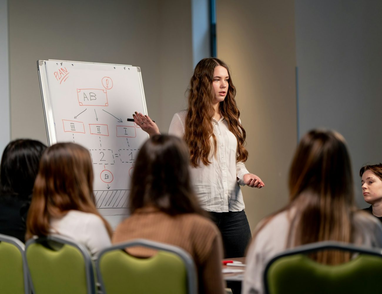 business conference or at hotel the girl on the flipchart shows the development plan for the company